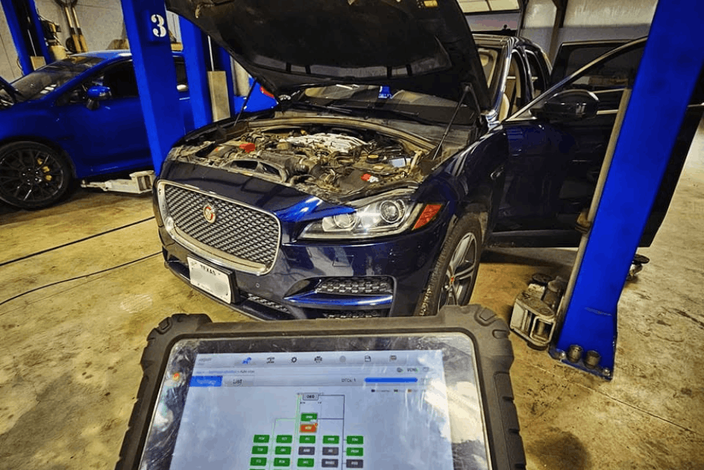 European auto repair in Haslet, TX, at Brittni's Automotive Repair. Image of Jaguar SUV undergoing computerized engine diagnostics with a professional scan tool to identify check engine light issues and other vehicle performance problems.