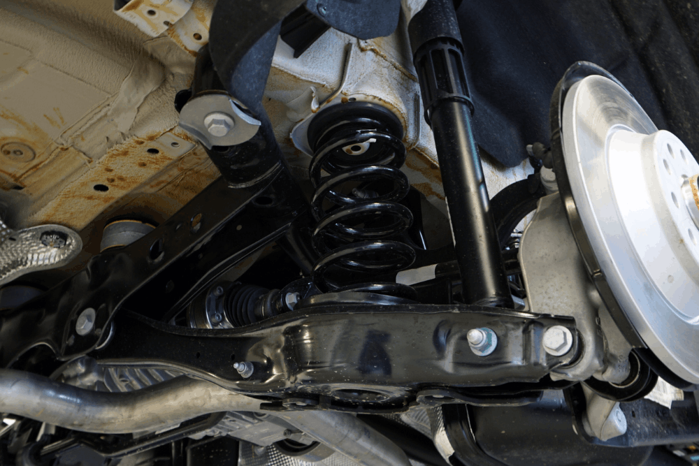 Suspension repair in Haslet, TX, at Brittni's Automotive Repair. Image of a vehicle's suspension system with new coil spring, shock absorber, and brake components installed, highlighting expert repairs that improve ride quality, handling, and safety.